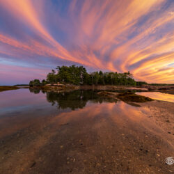 Sunset sky reflected in calm tidal water at Stockbridge Point in Winslow Park, Freeport, Maine