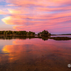 Pastel sunset clouds reflected in calm tidal water near Pound of Tea Island in Freeport, Maine