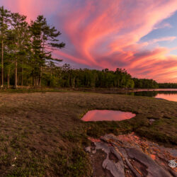 Sunset clouds reflected in a small tidal pool at Stockbridge Point in Freeport, Maine