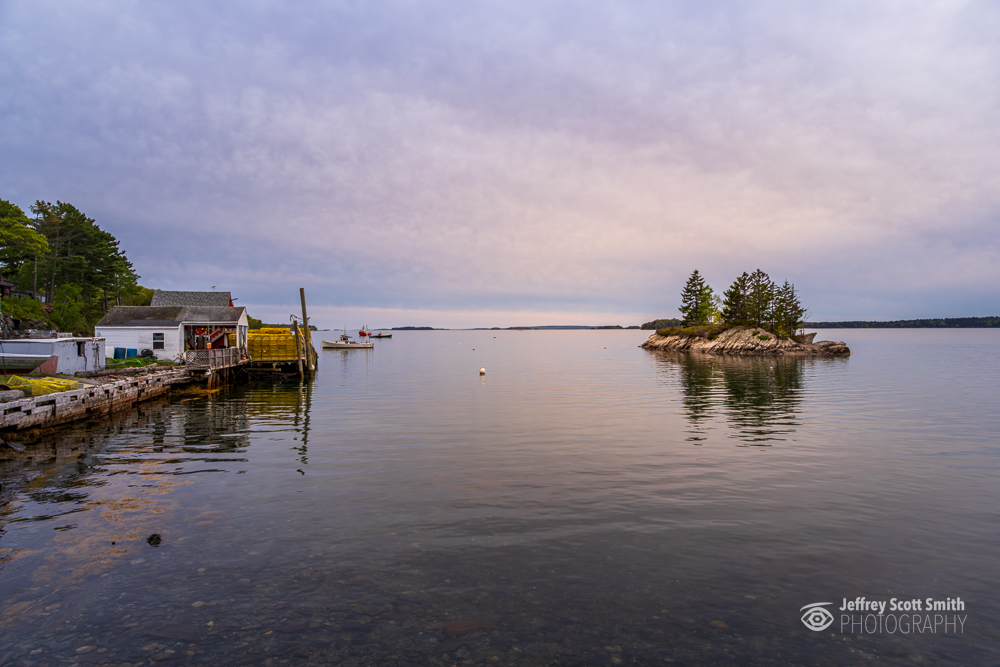 Working waterfront and small rocky island at Lookout Point in Harpswell, Maine during calm evening light